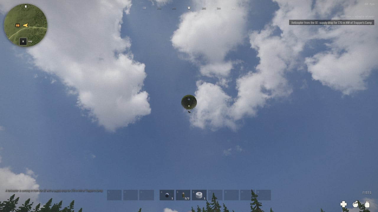 First person looking up: a crate under a round green canopy high against blue sky and clouds, and at the top right the line: Helicopter from the SE, supply drop for 370 m NW of Trapper's Camp