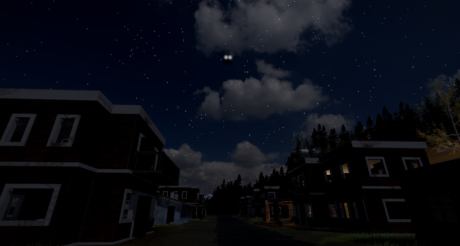 The same street at night, from the same place, before the change: the helicopter 50 m up shows two small lamps and the road under it is dark