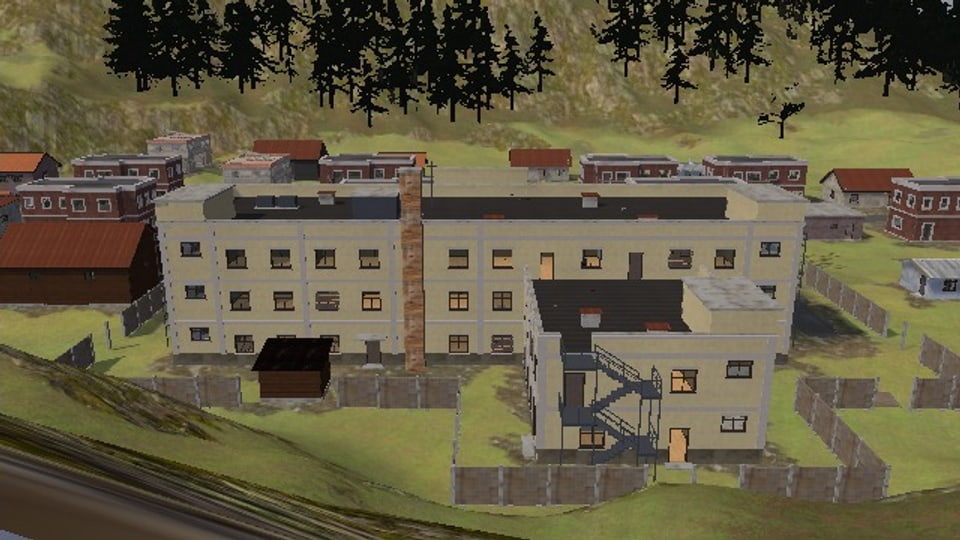 The hospital from behind and above: a two-floor wing built out from its back with steel stairs up its end wall to a terrace on its roof, a brick chimney, the wall of concrete slabs round the grounds
