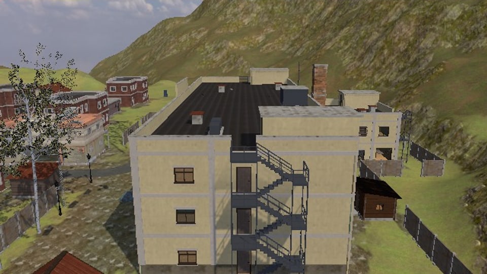 The end wall of the hospital: steel stairs in four flights up the outside of it, a door onto a landing at each floor, and on to the roof