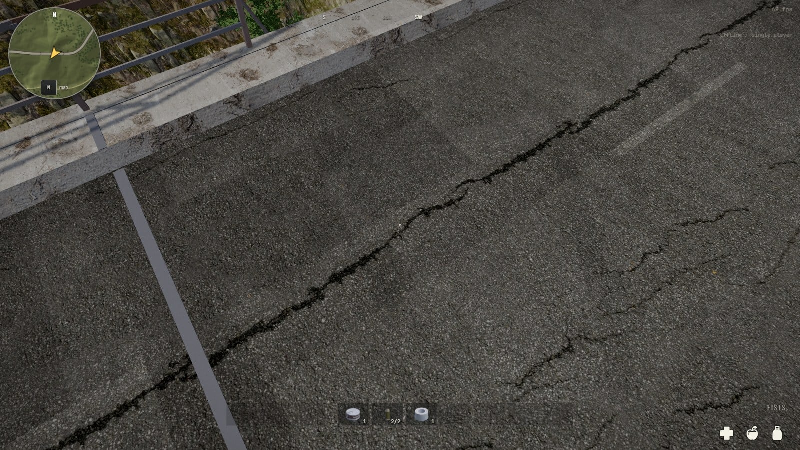 Looking down at the deck of the bridge: cracked asphalt with a worn white line, the raised concrete footway along its edge and the steel railing beyond it, tree tops far below