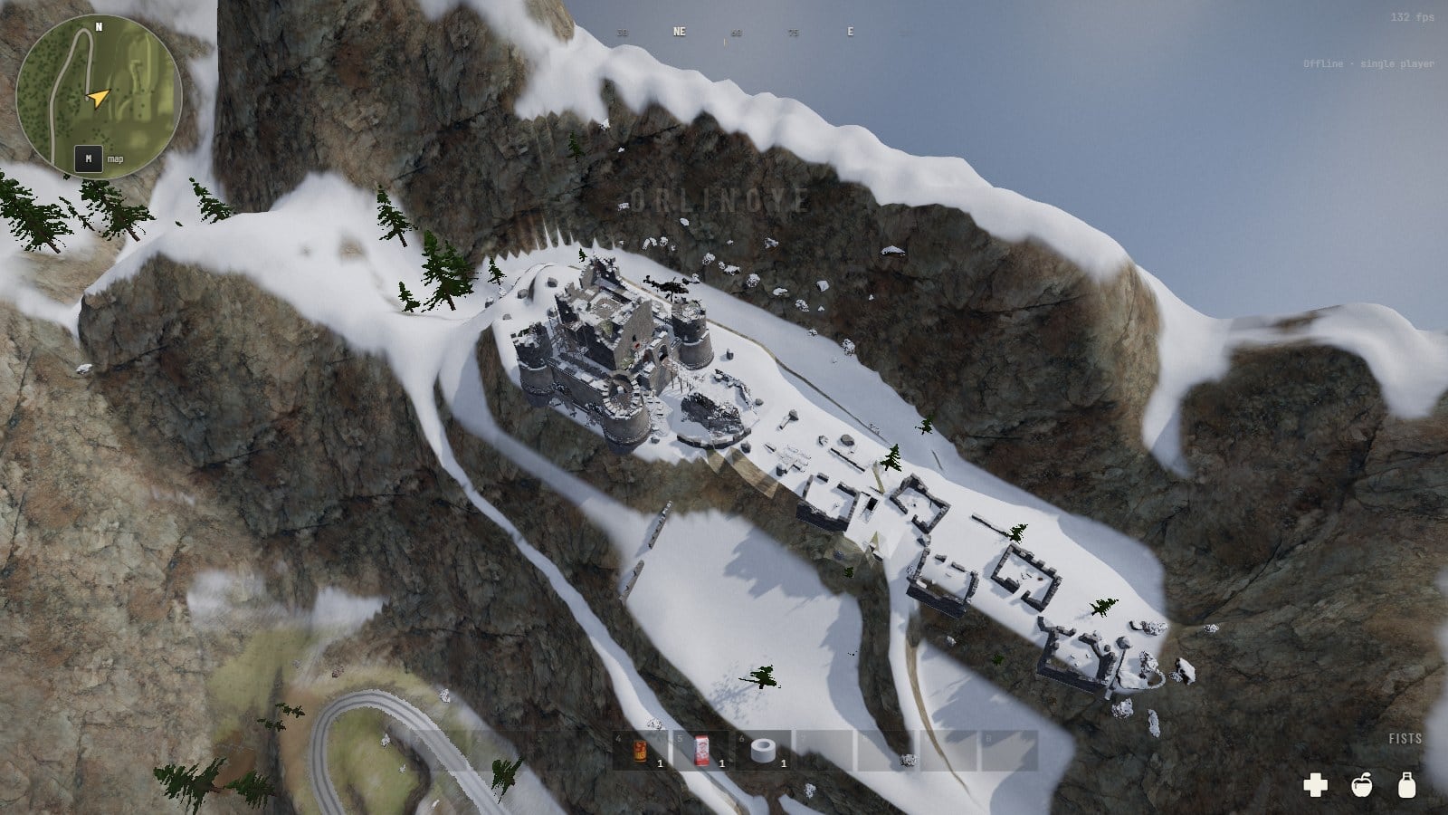 The crest from the air, all under snow: the fort at its far end, the roofless shells of a village in a row along the saddle before it, rock faces falling away on both sides, and at the bottom left the hairpin of the mountain road